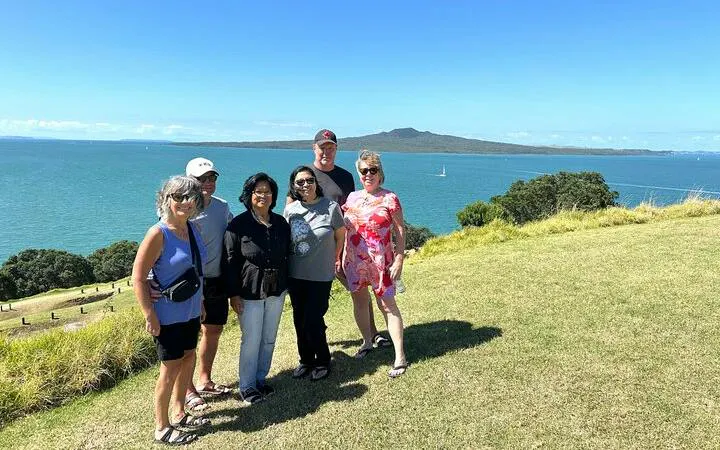 Group enjoying scenic view of Rangitoto Island from Auckland, part of a half-day sightseeing tour.