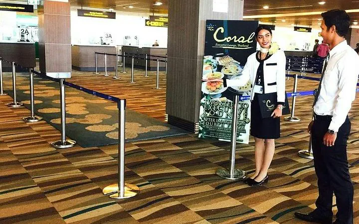 Phuket Airport staff guiding passenger through fast-track immigration service.