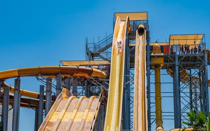 Water slides at The Land of Legends Theme Park, Turkey, with people enjoying the ride.