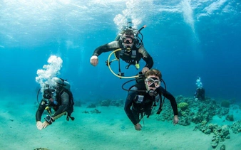 Scuba divers exploring coral reefs in Hurghada during a two-stop diving trip.