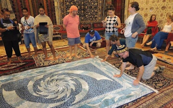 Group examining handmade carpets on Cappadocia shopping tour.