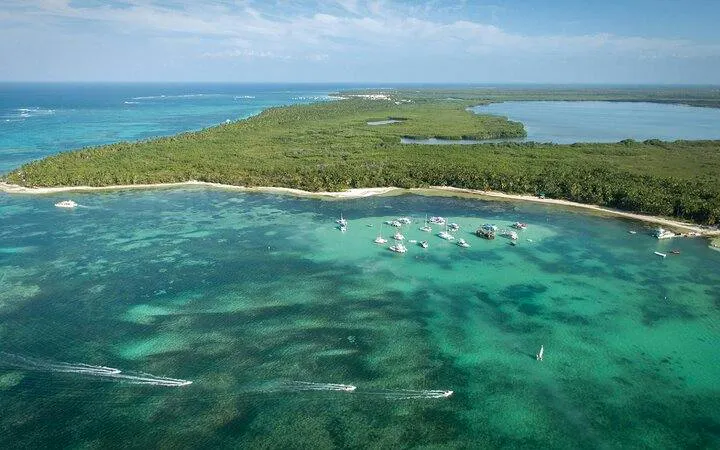 Aerial view of boats near a lush coastline in Punta Cana, ideal for private sailing and snorkeling.