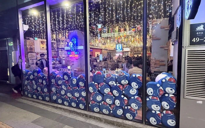 Seoul restaurant with festive lights, offering chimaek experience with fried chicken and beer.