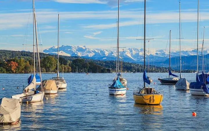 Sailboats on Lake Zurich with Swiss Alps in the background during Zurich city tour.