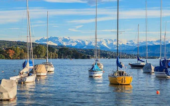 Sailboats on Lake Zurich with Swiss Alps in the background during Zurich city tour.
