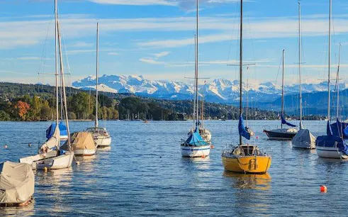 Sailboats on Lake Zurich with Swiss Alps in the background during Zurich city tour.