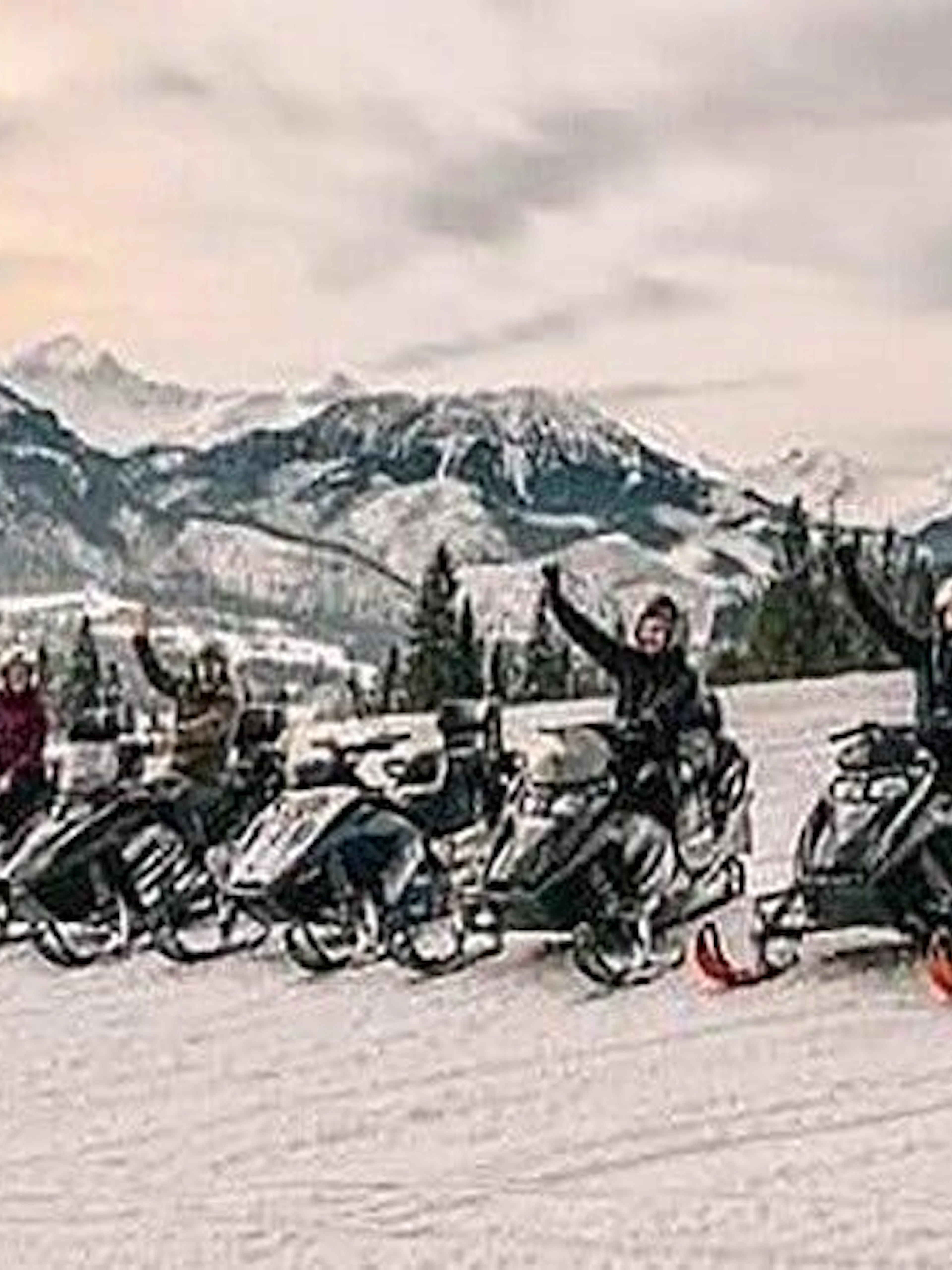 Snowmobilers in Zakopane with mountain backdrop during guided adventure tour.