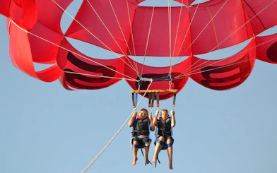 Parasailing over the Red Sea with red parachute, Hurghada adventure.