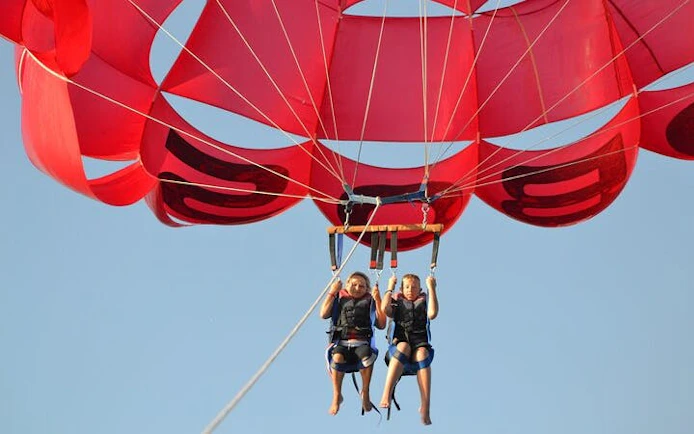 Parasailing over the Red Sea with red parachute, Hurghada adventure.