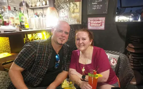 Couple enjoying drinks at a rooftop bar during Bangkok Tuk Tuk Street Food Tour.