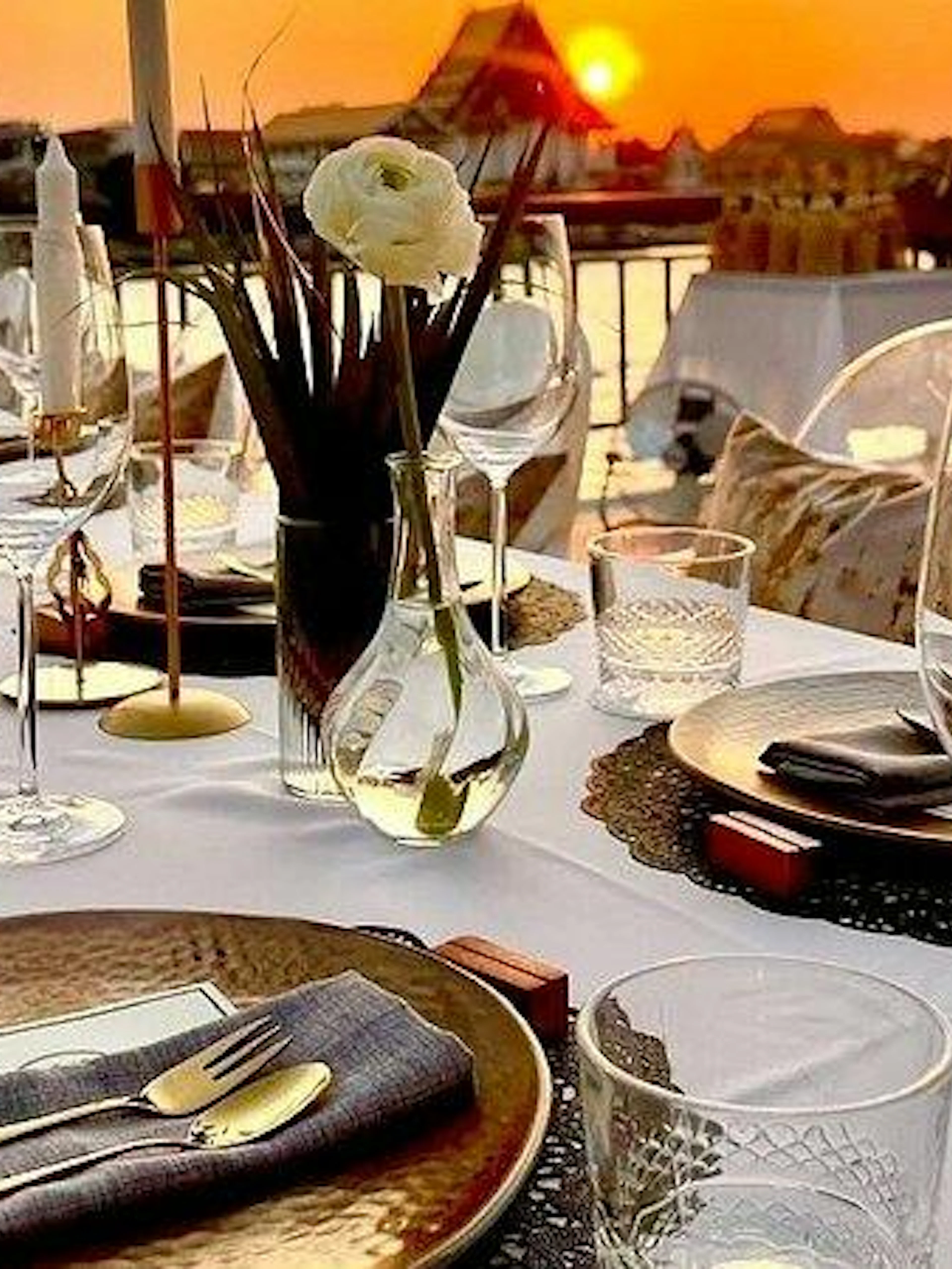 Fine dining setup by Chao Phraya River at sunset, Bangkok.