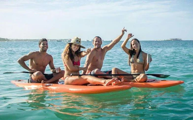 Small group enjoying paddle boards on a catamaran snorkeling cruise in Punta Cana.