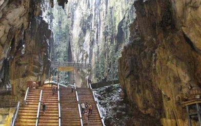 Staircase leading to Batu Caves entrance in Kuala Lumpur, surrounded by limestone formations.