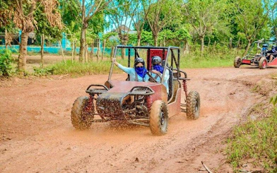 Tourists driving a buggy on a dirt path during the Punta Cana Jungle Buggy Guided Tour.