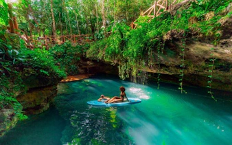Snorkeling in a lush cenote surrounded by greenery on America's largest reef tour.