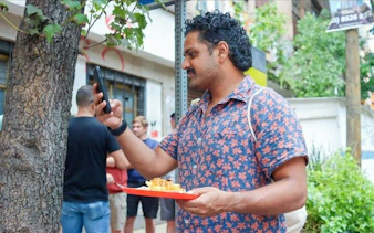 Man photographing tacos on a street in Mexico City.