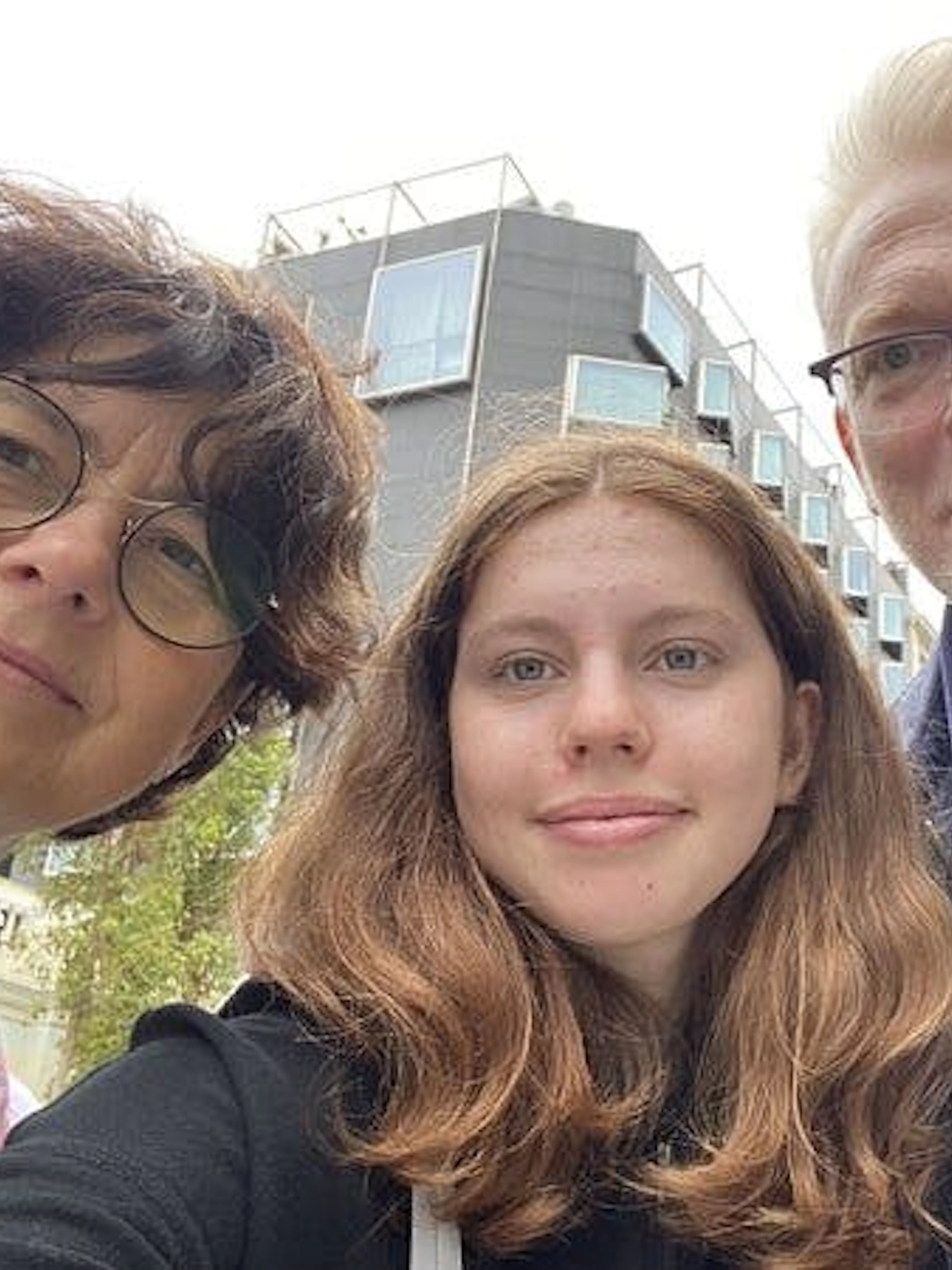 Three people in front of a modern building in Barcelona, exploring the city on a self-guided tour.