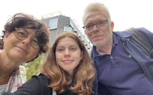 Three people in front of a modern building in Barcelona, exploring the city on a self-guided tour.