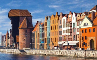 Colorful historic buildings along the Motława River in Gdansk, featured in a self-guided audio tour.