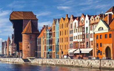 Colorful historic buildings along the Motława River in Gdansk, featured in a self-guided audio tour.