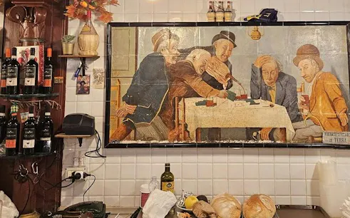 Wall art depicting men playing cards in a Florence trattoria, with wine bottles and bread on the counter.