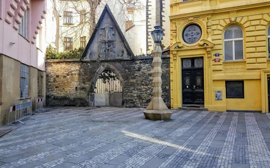 Courtyard with Gothic archway and ornate lamp post in Prague.