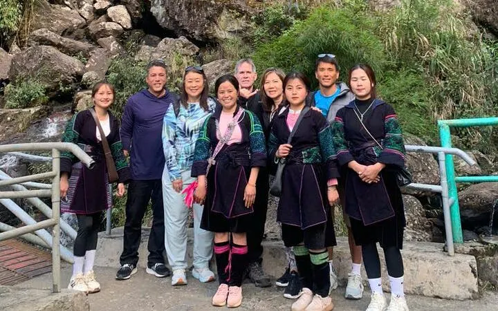 Group of tourists and local guides on Sapa motorbike tour in a rocky valley.
