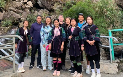 Group of tourists and local guides on Sapa motorbike tour in a rocky valley.