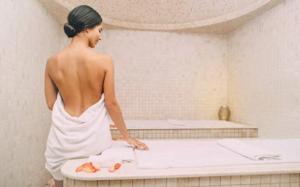 Turkish bath with woman in towel, Sharm El Sheikh spa experience.