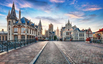 Bruges historical buildings and cobblestone street at sunset during day trip from Brussels.