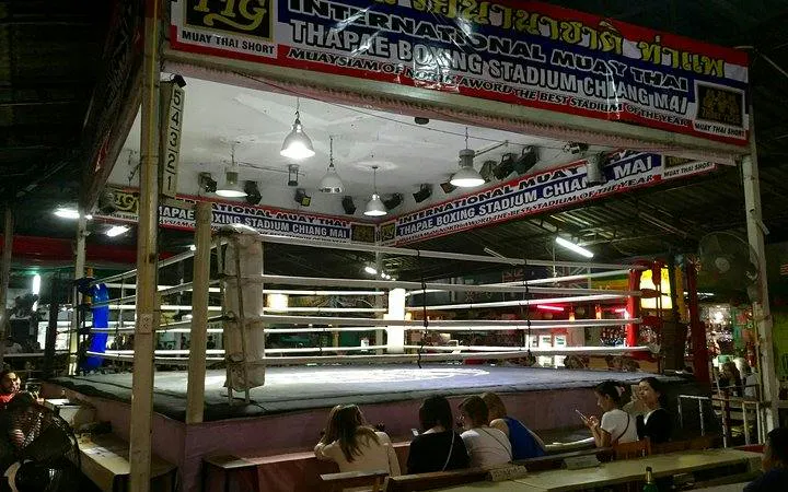 Thapae Stadium Muay Thai boxing ring in Chiang Mai with spectators seated nearby.