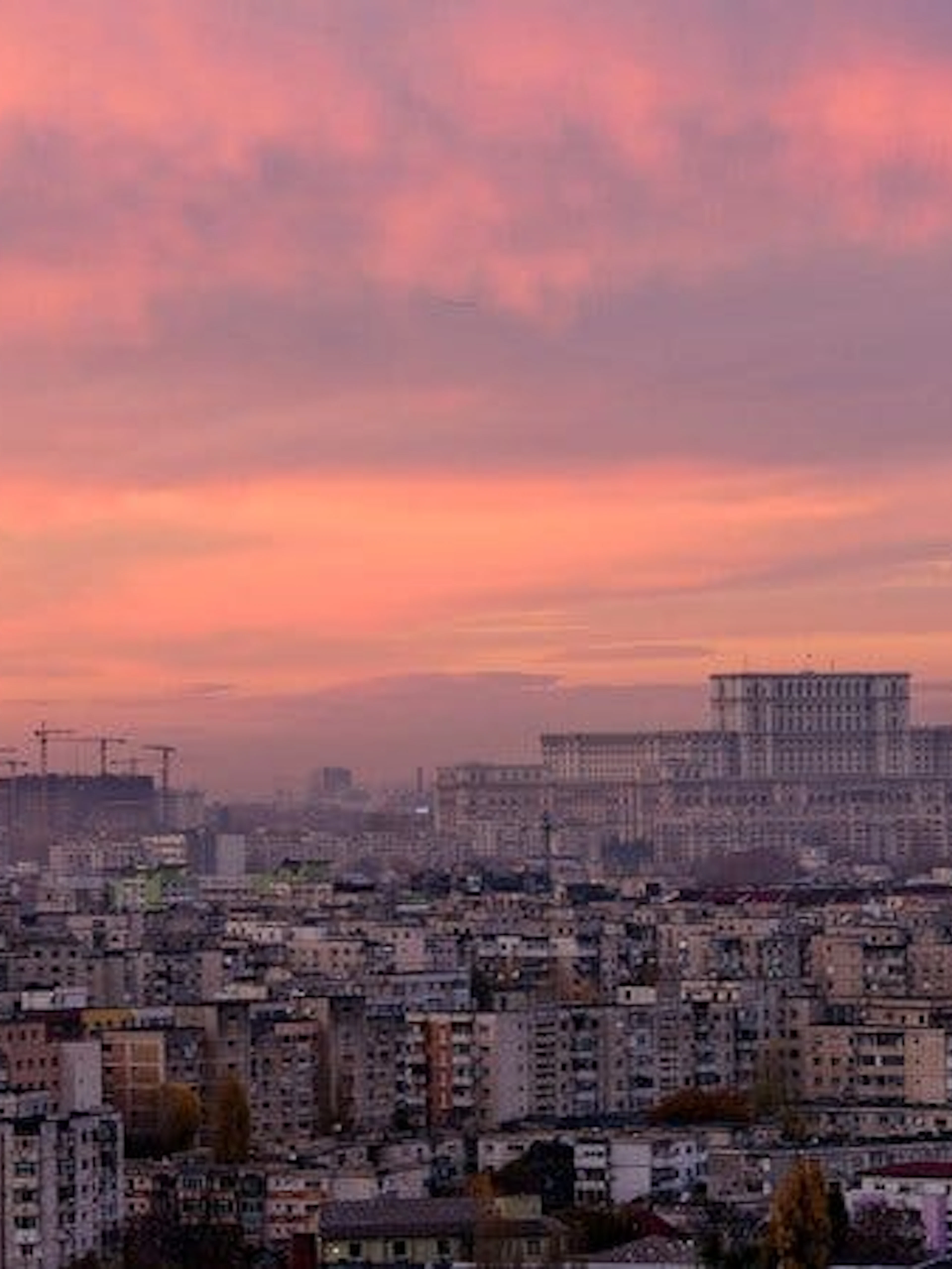 Bucharest skyline at sunset with Palace of the Parliament in view.