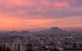 Bucharest skyline at sunset with Palace of the Parliament in view.