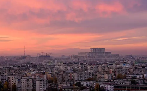 Bucharest skyline at sunset with Palace of the Parliament in view.