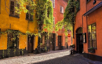 Cobblestone street in Stockholm's Gamla Stan with colorful historic buildings.