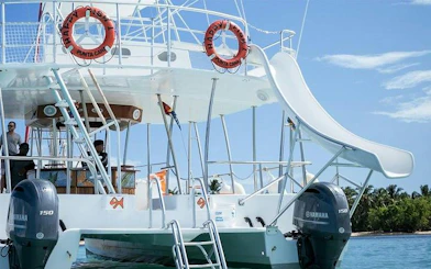 Catamaran with slide and open bar in Punta Cana, ready for snorkeling cruise.