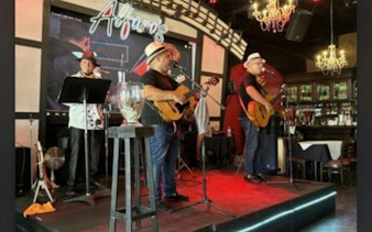Musicians performing live with guitars at a venue in Little Havana, Miami.