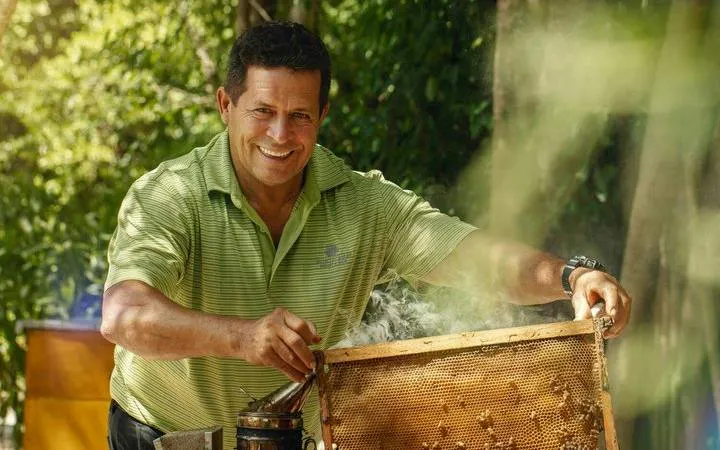 Man demonstrating beekeeping techniques in Punta Cana wildlife conservation tour.