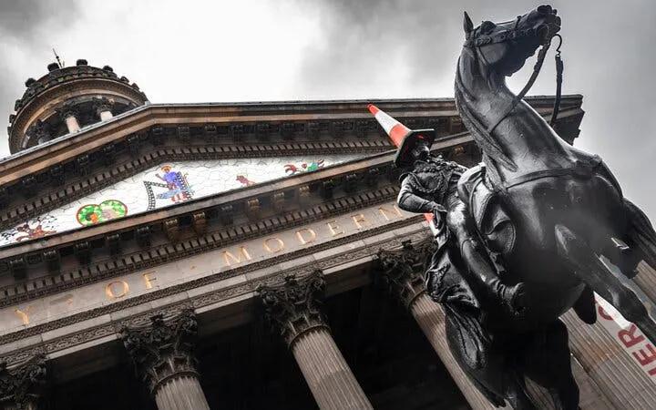 Equestrian statue with traffic cone in front of Glasgow's Gallery of Modern Art.