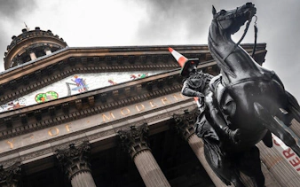 Equestrian statue with traffic cone in front of Glasgow's Gallery of Modern Art.