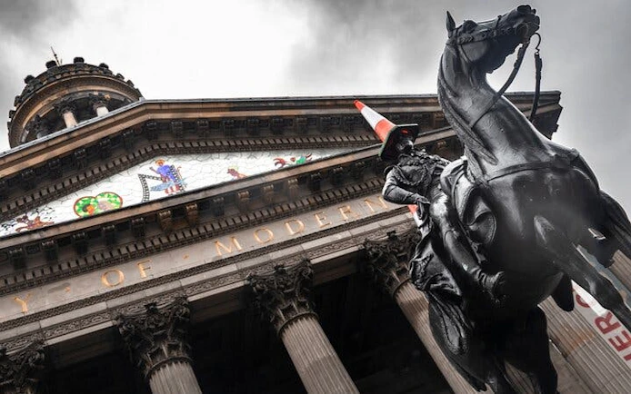 Equestrian statue with traffic cone in front of Glasgow's Gallery of Modern Art.