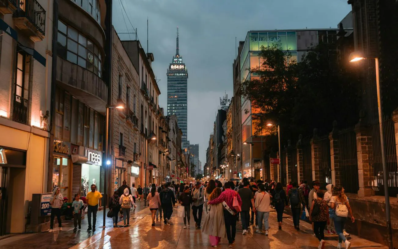 Crowded street in Mexico City's Centro Histórico with Torre Latinoamericana in the background.