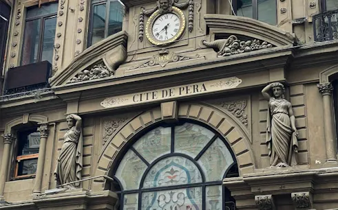 Facade of Cité de Péra with statues and clock, part of Galata Tower self-guided audio walk in Istanbul.
