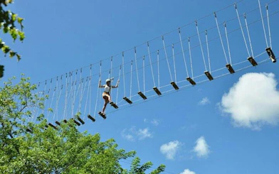 Person crossing a hanging bridge in Punta Cana zipline adventure.