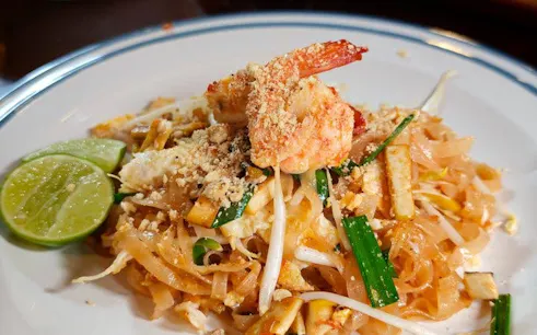 Pad Thai with shrimp and lime served during Thai cooking class at historic garden house.