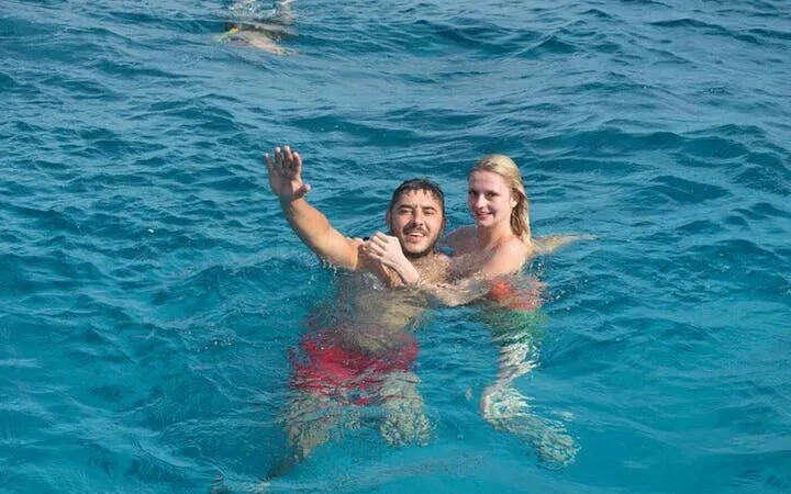 Couple swimming in clear blue sea during Sharm El Sheikh speedboat tour.