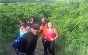 Group hiking through lush greenery on St. Maarten trail to island’s highest point.