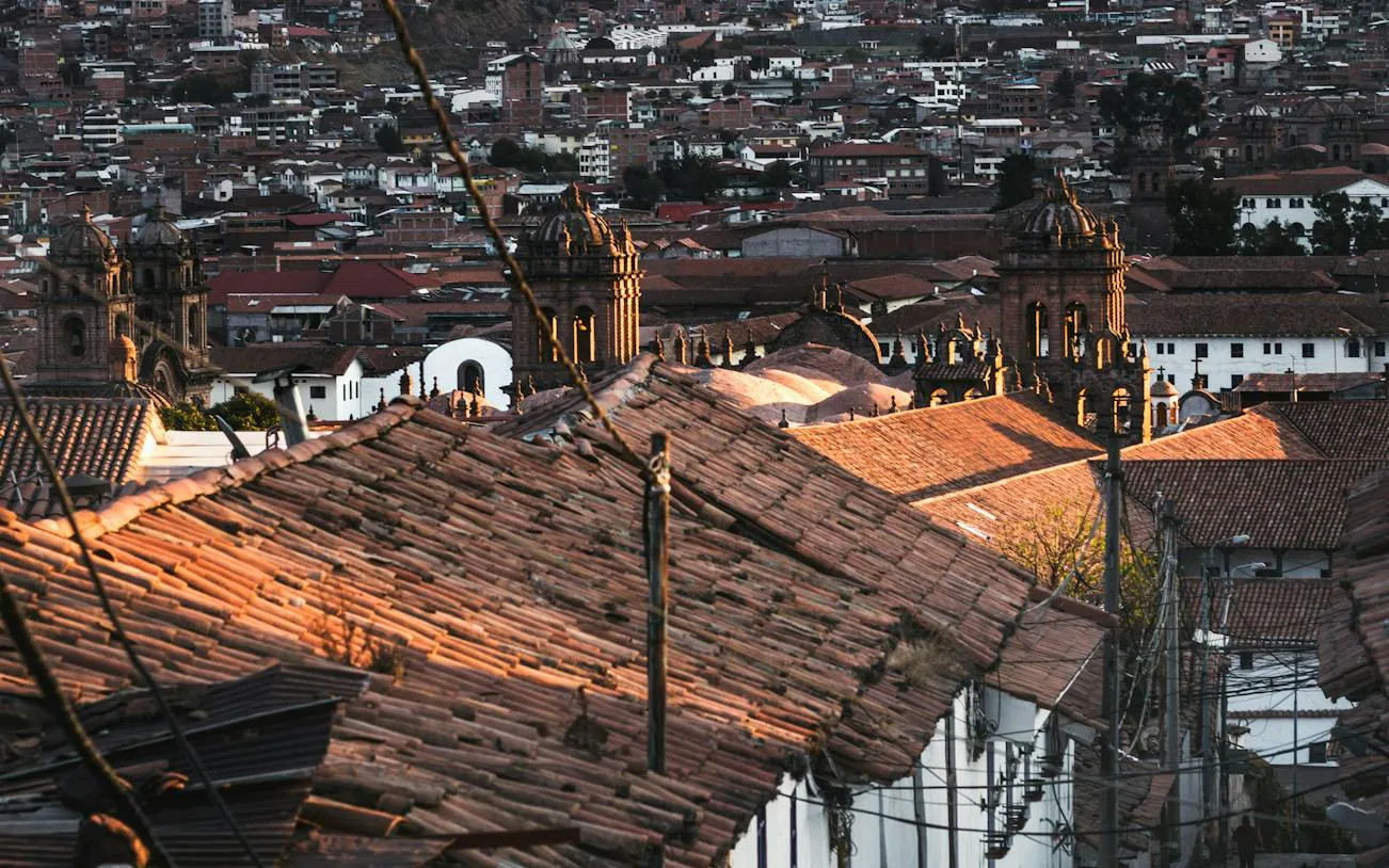 Cusco cityscape with Inca walls and San Blas rooftops at sunset, Peru.
