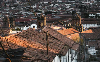 Cusco cityscape with Inca walls and San Blas rooftops at sunset, Peru.