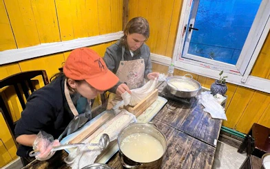 Two people making tofu in a Sa Pa cooking class using traditional Vietnamese methods.